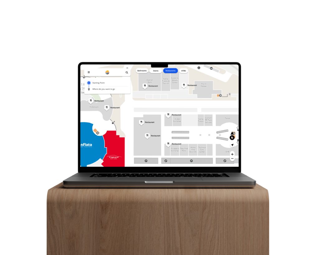 A Macbook Pro resting on a wooden shelf shows an interactive digital map of a shopping center.