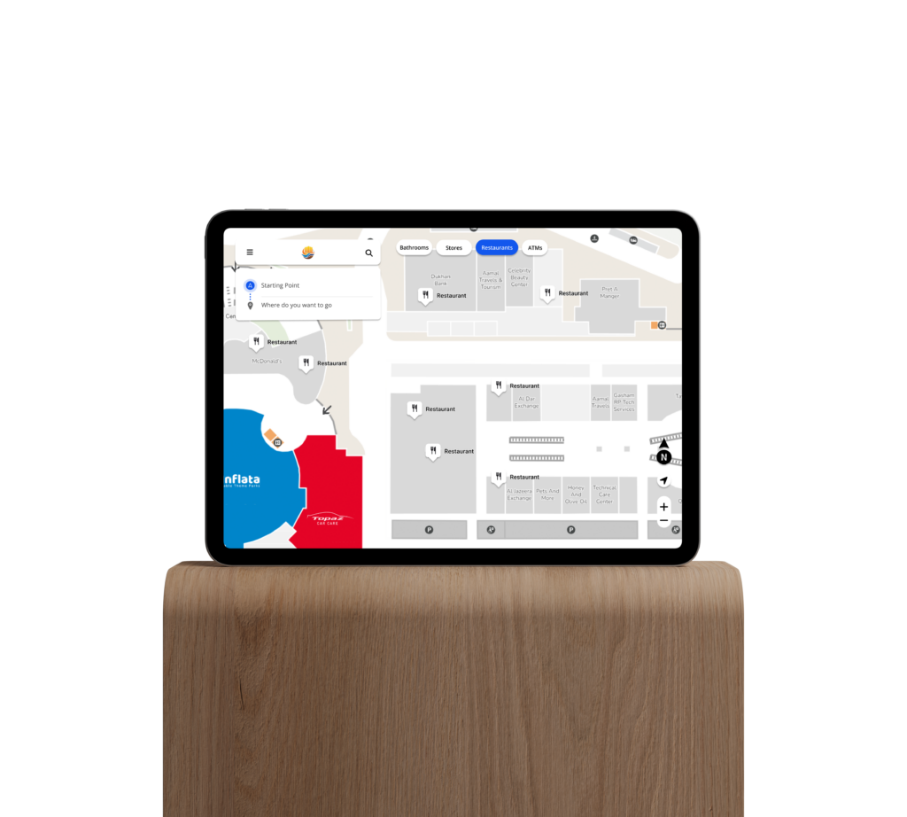 A tablet resting on a wooden shelf shows an interactive digital map of a shopping center.